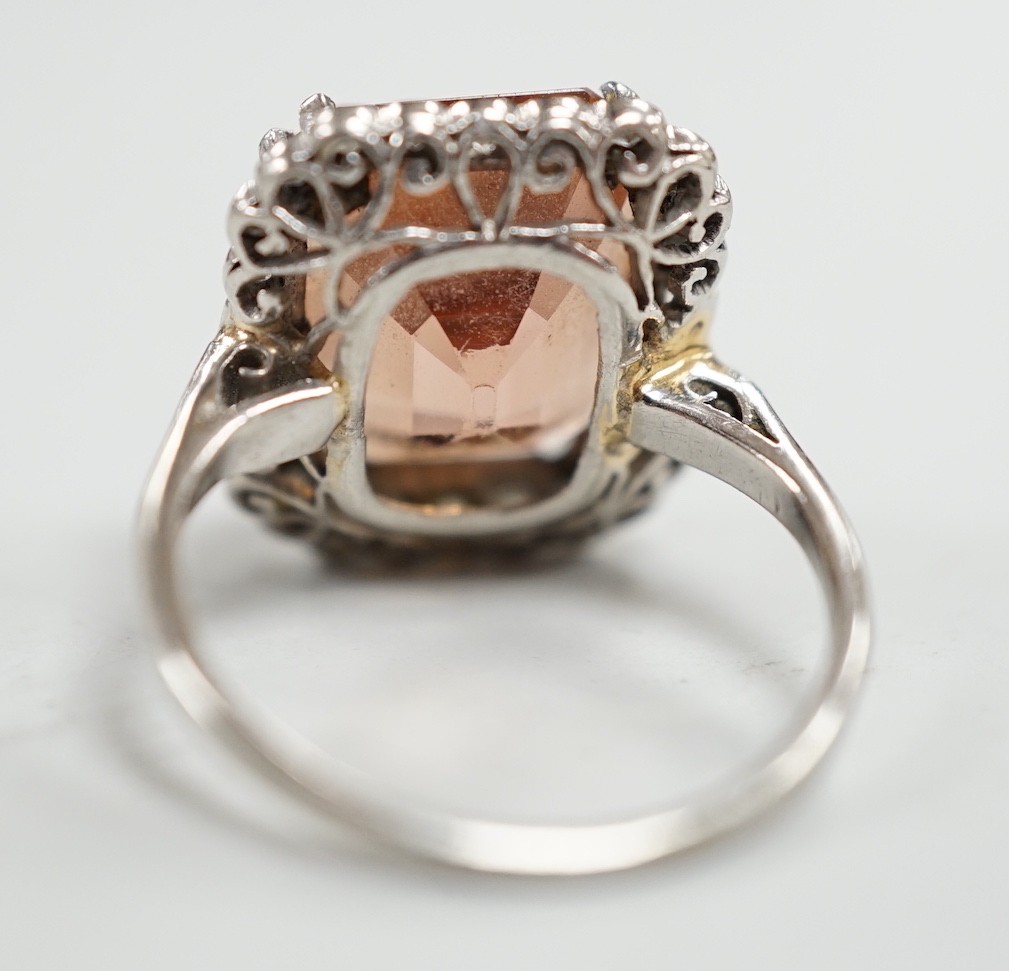 A white metal and emerald cut orange/peach topaz set dress ring, with diamond set border, size I/J, gross weight 6.1 grams.